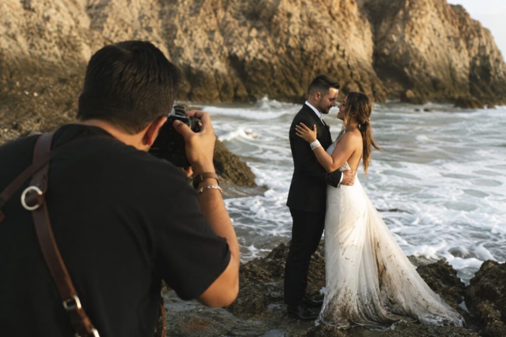Fotógrafo profesional tomando fotos a pareja de novios en sesión posterior al aire libre